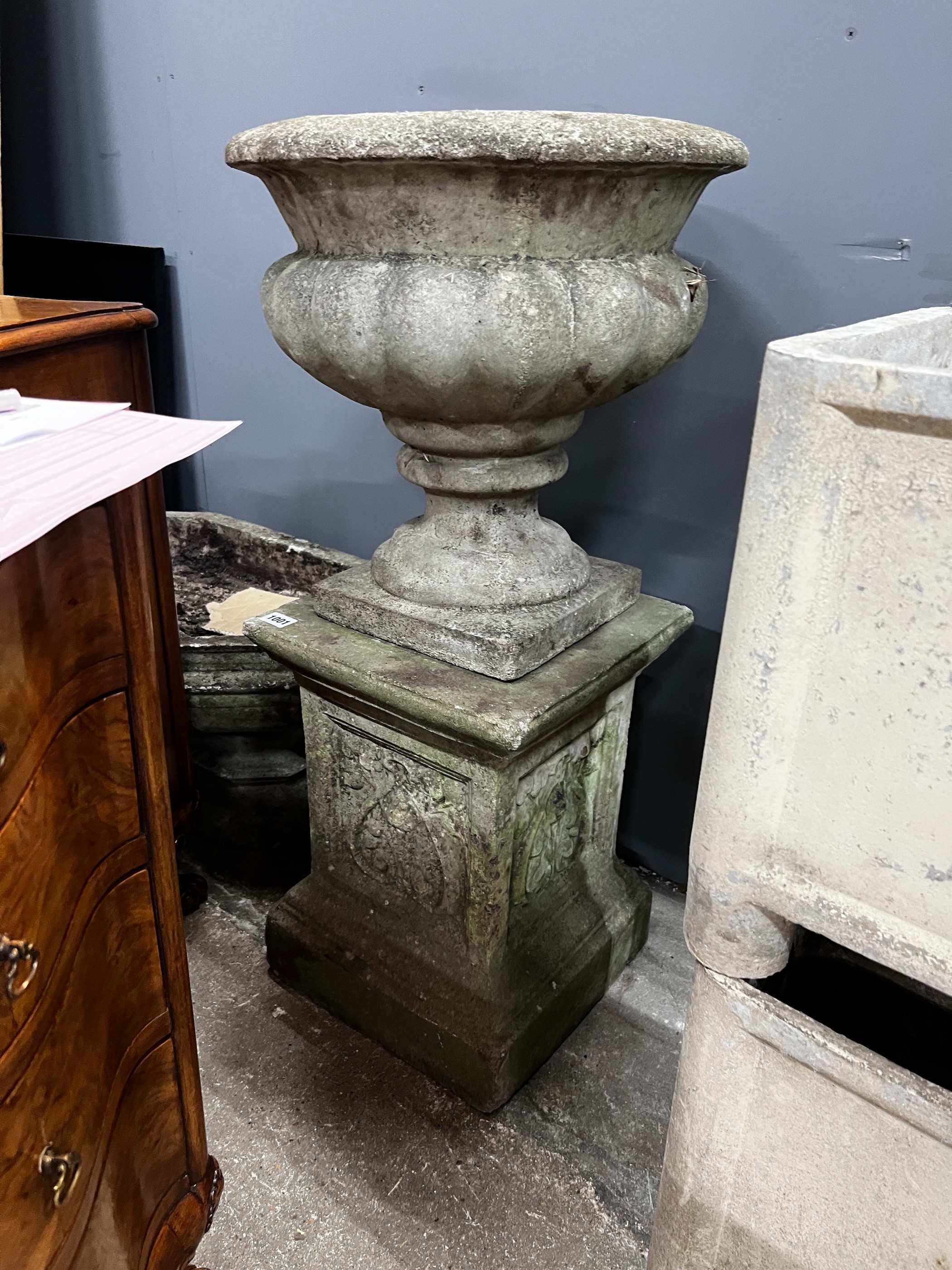 A circular reconstituted stone garden planter on square plinth, diameter 40cm, height 84cm together with an octagonal shallow stone planter, width 62cm, height 33cm